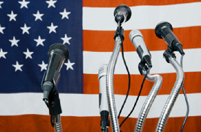 Press conference microphones and an American flag